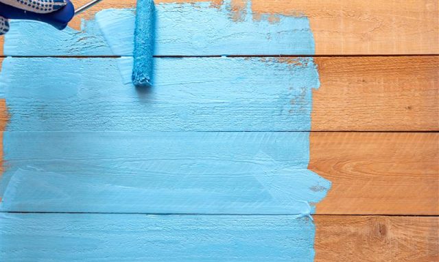 painting-with-paint-roller-blue-color-paint-green-paint-tray-wooden-diy-background