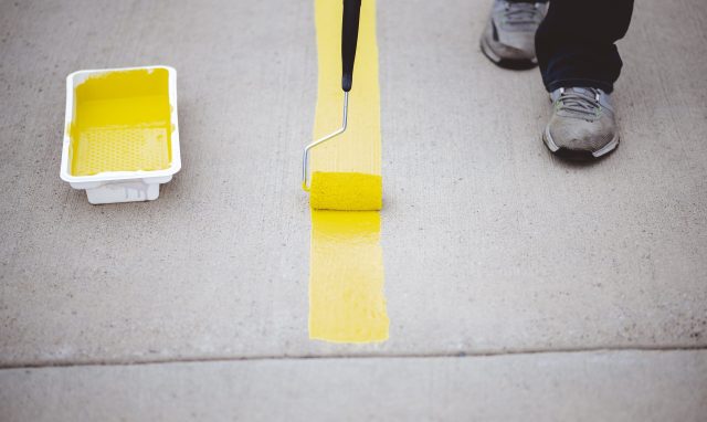 view-person-repainting-parking-lines-asphalt-parking-lot-with-yellow-paint 1-min